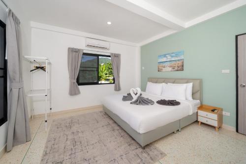 a bedroom with a white bed and a window at Golden Sands Villa only 15 minutes walk to beach in Ban Lum Fuang