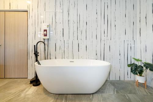 a large white bath tub in a bathroom at Golden Sands Villa only 15 minutes walk to beach in Ban Lum Fuang