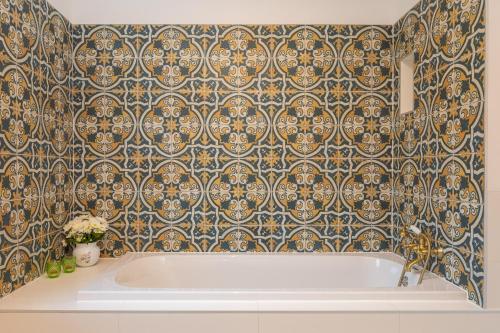 a bath tub in a bathroom with a tile wall at Villa Zvonimir in Klis
