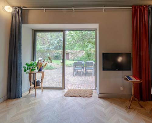 a living room with a large sliding glass door with a patio at Château Doré les Tours - Appartement Renard in Montfaucon