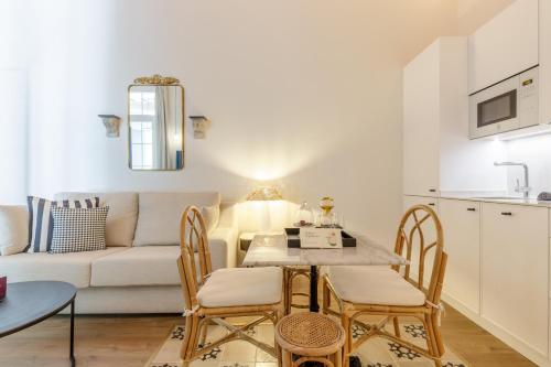 a living room with a table and chairs and a couch at Palacio Vegafuente by Caleta Homes in Málaga