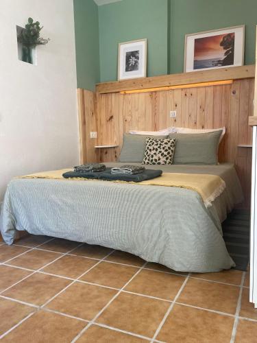 une chambre avec un grand lit avec une tête de lit en bois dans l'établissement Cosy studio - Place du Figuier, à Bormes-les-Mimosas