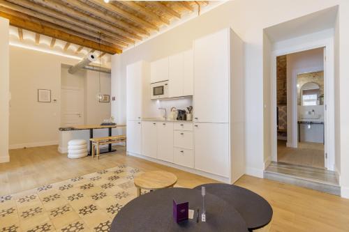 a kitchen with white cabinets and a table in a room at Palacio Vegafuente by Caleta Homes in Málaga
