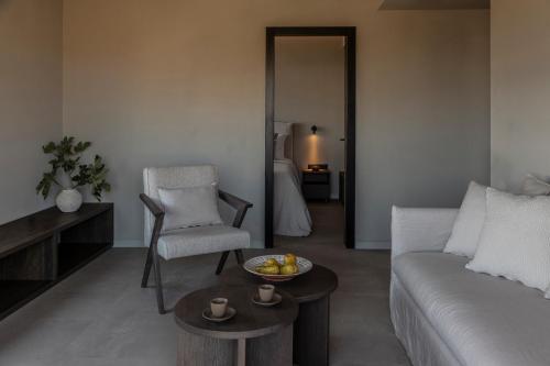 a living room with a couch and a table and a chair at Ela Tinos in Arnados