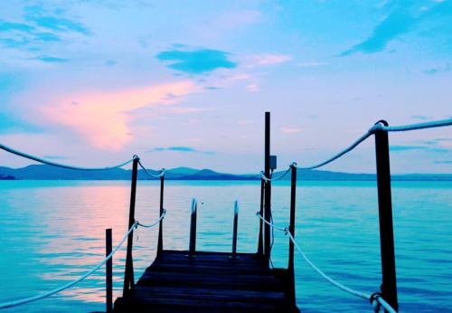 a dock on a body of water with a sunset at Sweet Dream in Passignano sul Trasimeno