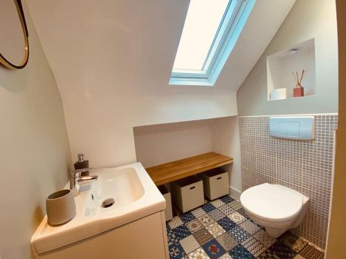 une salle de bain avec des toilettes blanches et un lavabo dans l'établissement L heurt du R Épi, à Le Portel