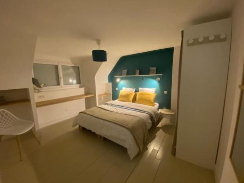 - une chambre avec un lit doté d'une tête de lit verte et d'oreillers jaunes dans l'établissement L heurt du R Épi, à Le Portel