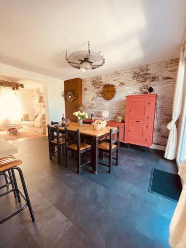 - une cuisine avec une table, des chaises et une armoire rouge dans l'établissement L heurt du R Épi, à Le Portel
