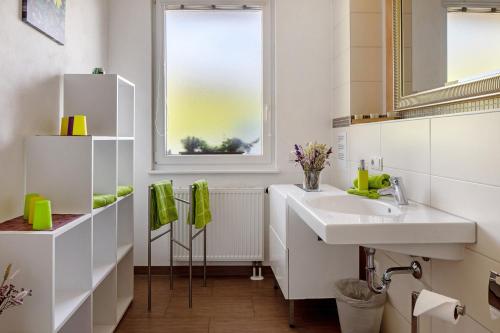 a white bathroom with a sink and a mirror at Sport Rees - Ferienwohnung Ulrike in Hofsgrund