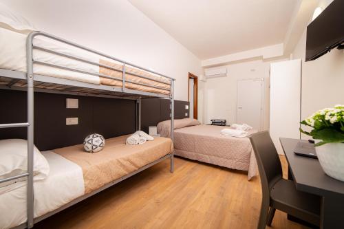 a bedroom with two bunk beds and a desk at Villaggio San Pellegrino in Misano Adriatico