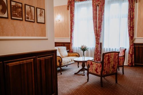a living room with a couch and a table and chairs at Kastélyhotel Sasvár Resort in Parádsasvár