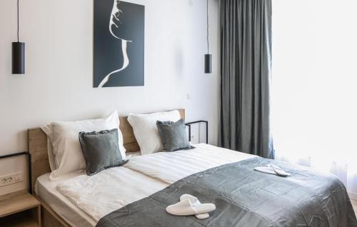 a bedroom with a bed with white shoes on it at Beautiful Home In Rokovci With Sauna in Rokovci