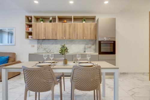 a kitchen with a dining room table and chairs at Stylish 2BR Getaway Steps from the Promenade in Sliema