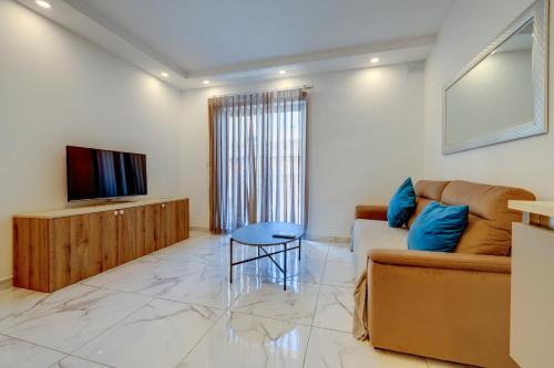 a living room with a couch and a tv at Stylish 2BR Getaway Steps from the Promenade in Sliema