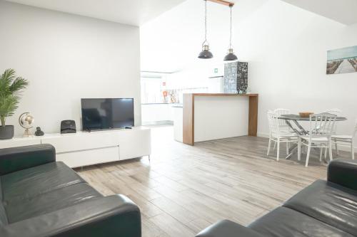 a living room with a couch and a tv at Viriato's House in Ribeira Grande