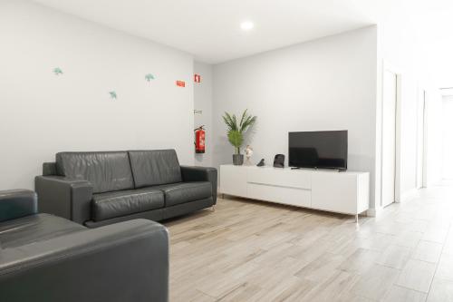 a living room with a couch and a flat screen tv at Viriato's House in Ribeira Grande
