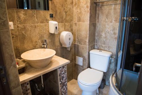 a bathroom with a toilet and a sink and a shower at MBI Travel Inn in Craiova