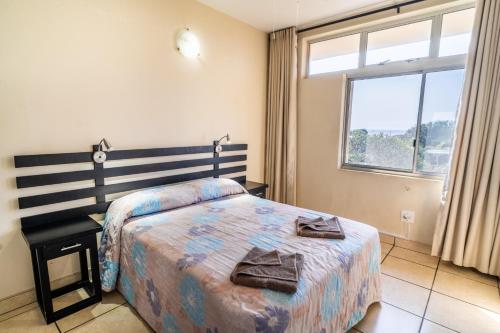 a bedroom with a bed and a window at ATKV Natalia in Kingsburgh