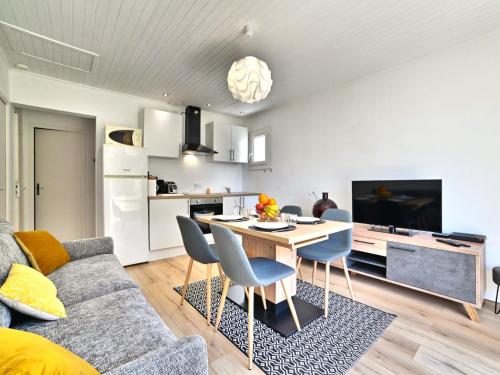 un salon avec un canapé et une table avec des chaises dans l'établissement Holiday Home Les Cariatides 2 by Interhome, à Saint-Pierre-dʼOléron