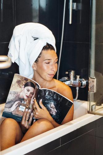 a woman sitting in a bath tub reading a magazine at Stay Hotel Torres Vedras Centro in Torres Vedras