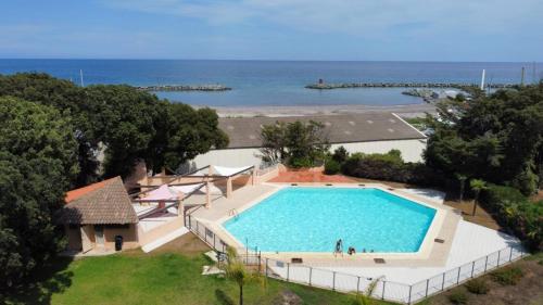 une vue aérienne d'une piscine à côté de l'océan dans l'établissement L'alisgianinca, à Santa-Maria-Poggio