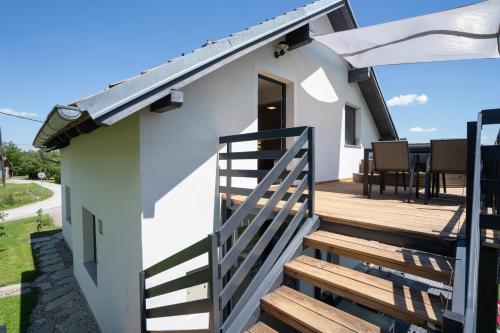 a small white house with a wooden deck at Lux Loft Spa in Rakovica