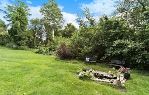 a garden with a bench and flowers in the grass at Awesome Home In Ølsted With Wifi in Ølsted