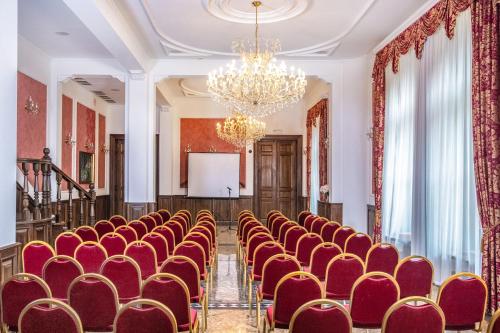 an empty room with red chairs and a podium at Kastélyhotel Sasvár Resort in Parádsasvár