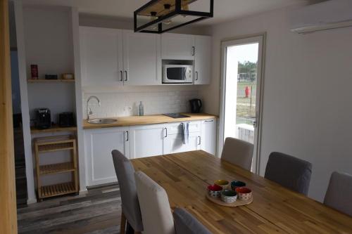 une cuisine avec une table en bois et des chaises ainsi qu'une salle à manger dans l'établissement Dependance dans les Landes, à Escource