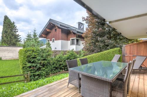 d'une terrasse avec une table en verre et des chaises. dans l'établissement Appartement Rothschild - garage - Welkeys, à Megève