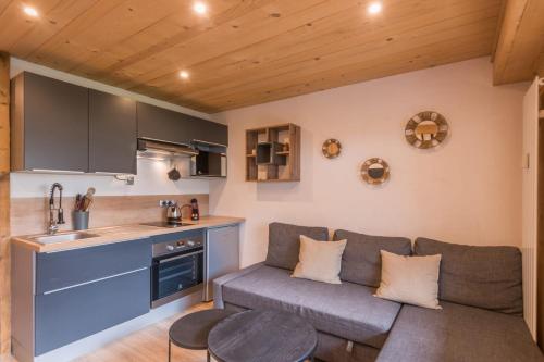 un salon avec un canapé et une cuisine dans l'établissement Appartement Rothschild - garage - Welkeys, à Megève