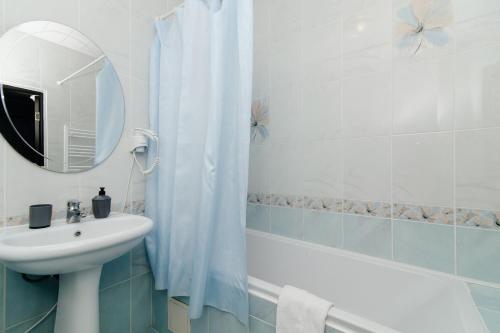 a bathroom with a sink and a mirror and a tub at ERA RENT Apartments in Chişinău