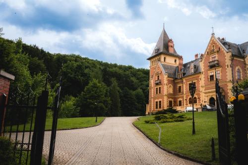 an old building with a tower on top of it at Kastélyhotel Sasvár Resort in Parádsasvár