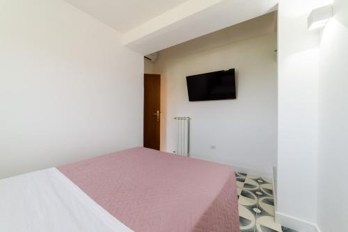 a bedroom with a bed and a tv on a wall at Relais Francesca Pool&View in Sorrento
