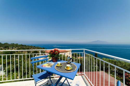 a blue table on a balcony with a view of the ocean at Relais Francesca Pool&View in Sorrento