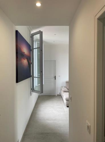 un couloir avec un miroir mural dans l'établissement Cosy flat 250m from beach, à Nice