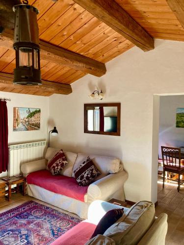 a living room with a couch and a wooden ceiling at Il Nascondiglio - The Hideaway in Amandola