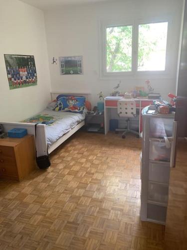 - une petite chambre avec un lit et du parquet dans l'établissement Charmante maison au calme proche de Paris, à Achères