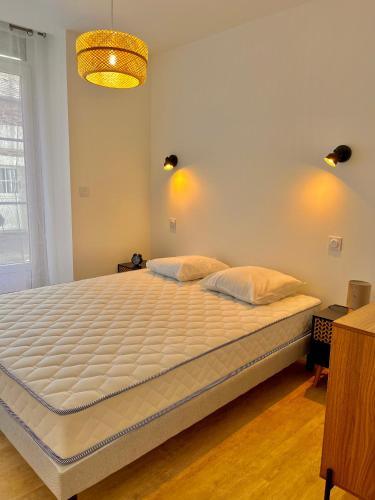 une chambre avec un grand lit avec des draps blancs dans l'établissement T2 Rez-de-chaussée, Le Victor Hugo, à Cancale