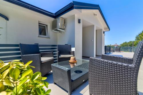 a patio with wicker chairs and a table at Apartmani Maka in Senj
