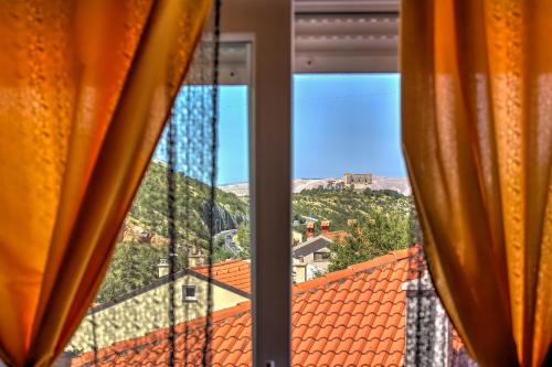 a view from a window with orange curtains at Apartmani Maka in Senj