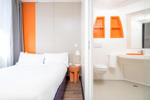 a bathroom with a bed and a toilet and a sink at Herculano Stays Porto - Digital Access in Porto