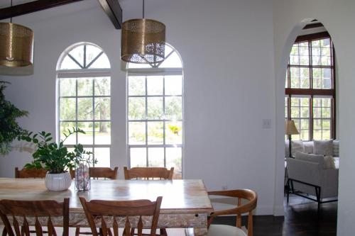 a dining room with a table and chairs and windows at Chateau Mariposa in Spring Hill