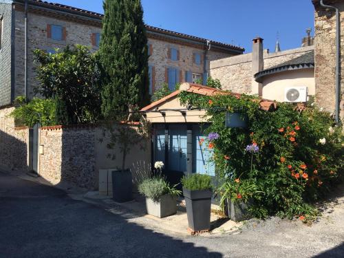 a building with plants and flowers in front of it at B&B La Boal in Dourgne