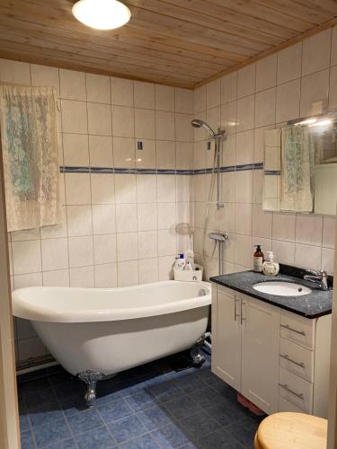TöcksforsにあるKoselig hytte i Sverige 20 minutter fra norskegrensen Ostervallskogの浴槽と洗面台のあるバスルーム