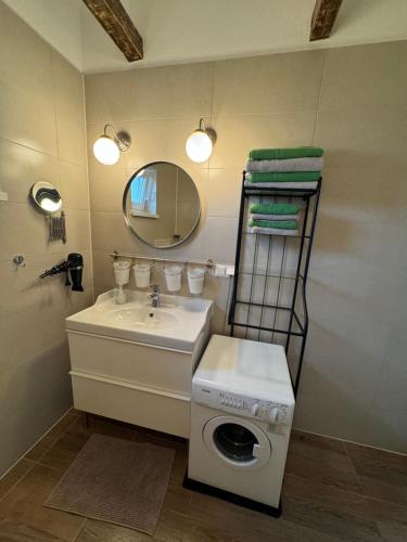 a bathroom with a washing machine next to a sink at Apartment Letica 2 in Malinska