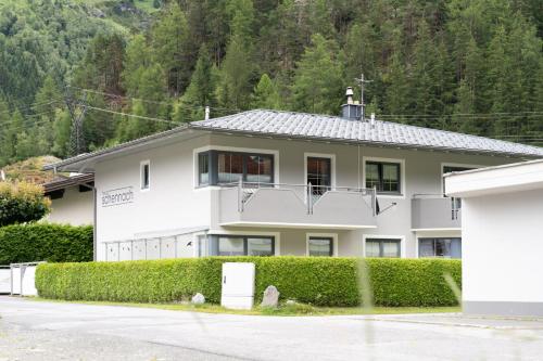 a white house with a hedge in front of it at Haus Schennach in Längenfeld