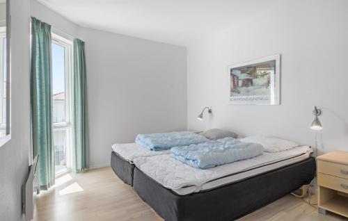 a bedroom with a bed with blue pillows on it at Gudhjem Søpark Lejl 24 in Gudhjem