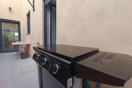 - un barbecue installé à côté d'un bâtiment dans l'établissement Charming T5 with garden and terrace, à Nice