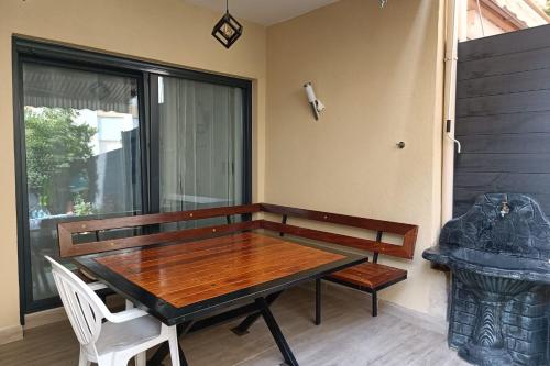 - une table et des chaises en bois dans une chambre avec fenêtre dans l'établissement Charming T5 with garden and terrace, à Nice